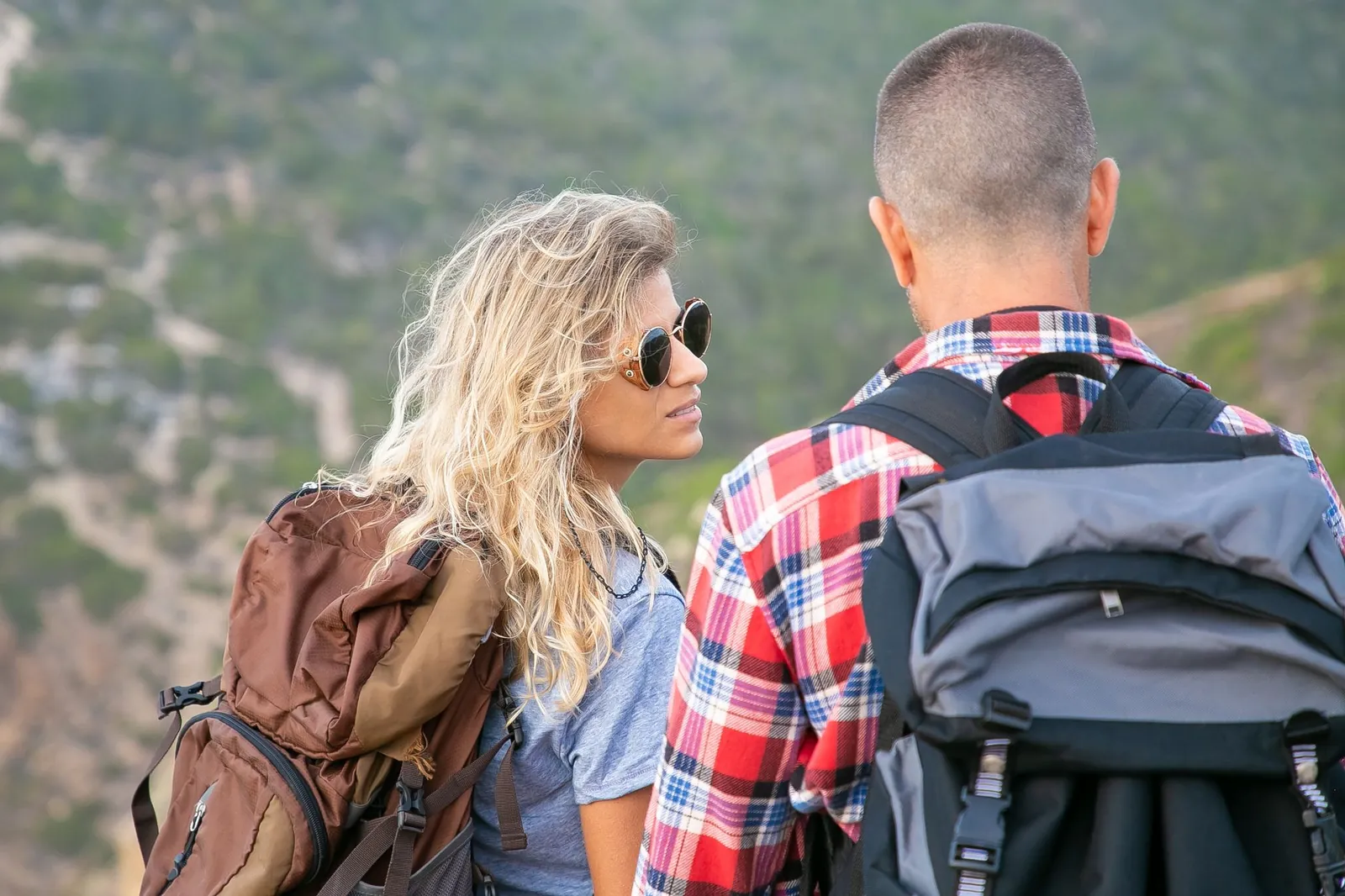 Osprey Rook 65 and Decathlon Quechua MH500 side by side on a granite trail showing size and hip belt comparison