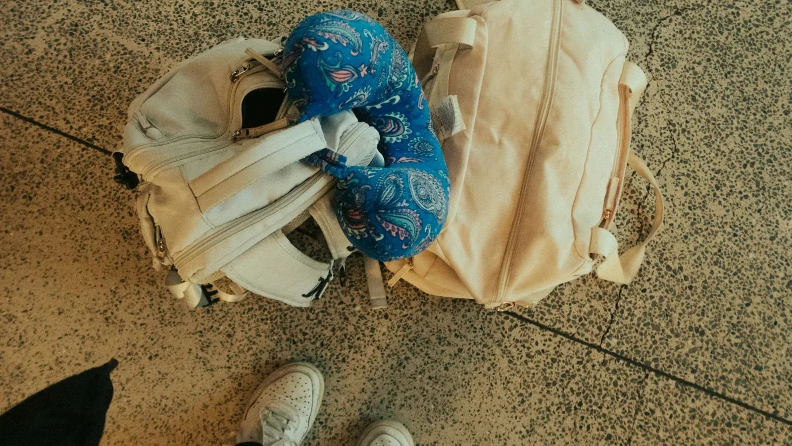 Memory foam neck pillow positioned on airplane seat headrest against window