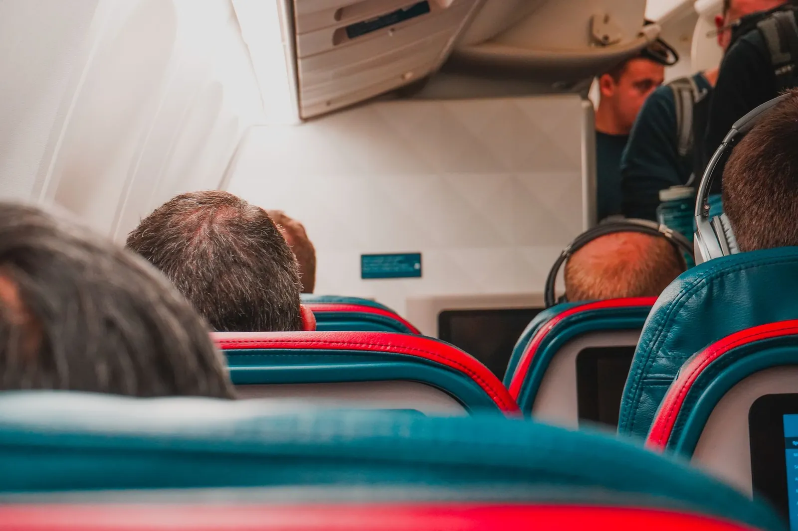 Memory foam neck pillow positioned on airplane seat headrest against window