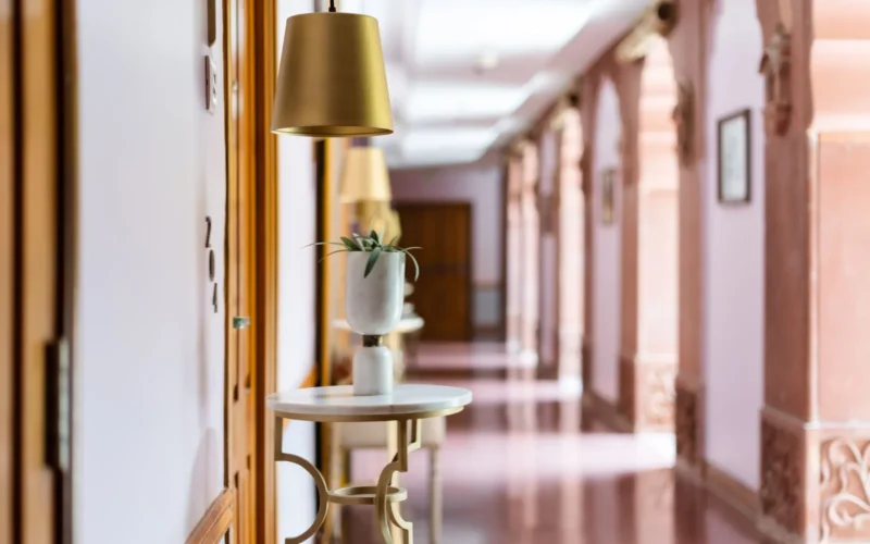 Narrow European street with small hotel entrance, warm lighting, and local storefronts