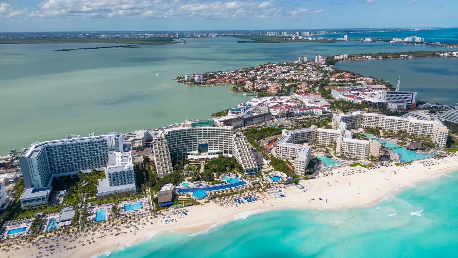 Aerial view of Cancun's Hotel Zone showing the curved beach and high-rise resorts lining the coast