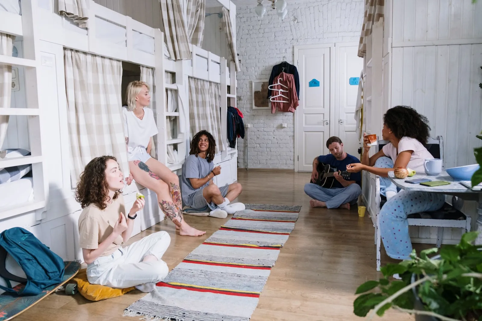 Hostel dorm room with four bunk beds and shared lockers beside a budget hotel room with a double bed and private ensuite bathroom