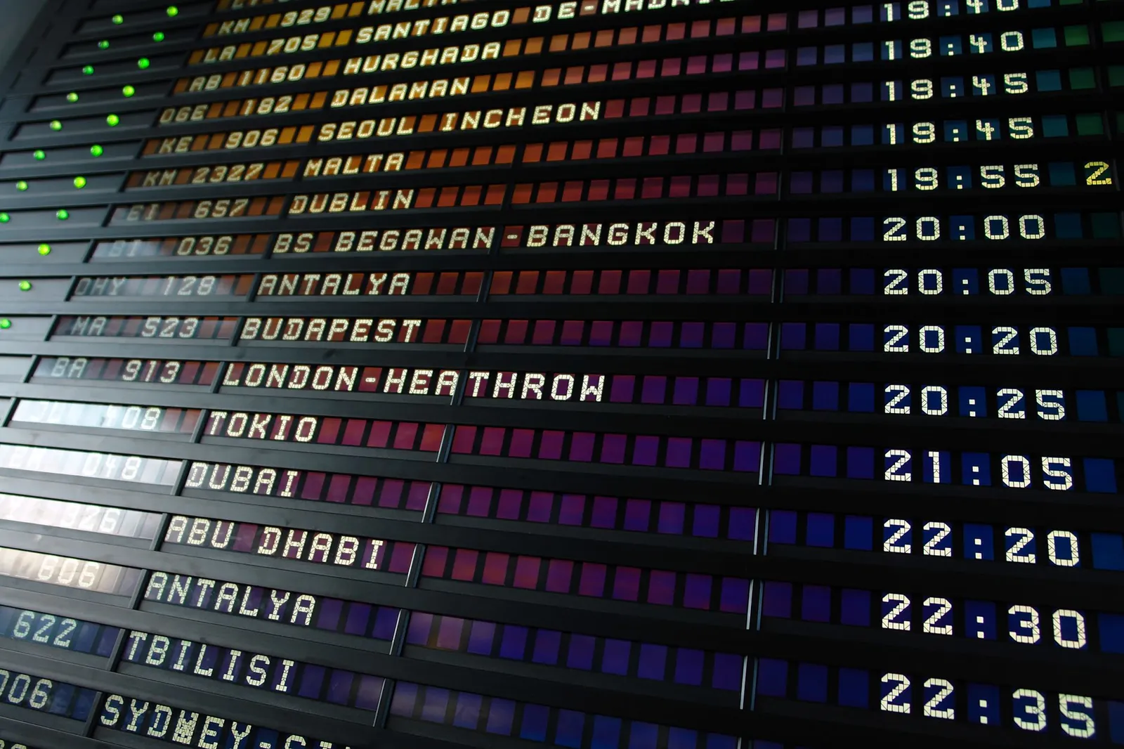 International departures hall with check-in counters and overhead flight boards at a major US hub airport