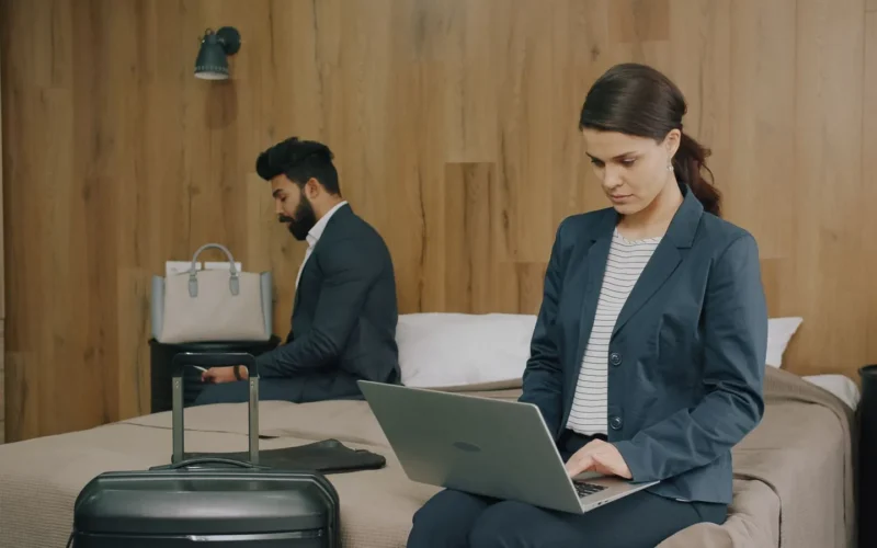 Laptop screen showing four hotel booking sites open in separate tabs with price differences of $30–$80 for the same room