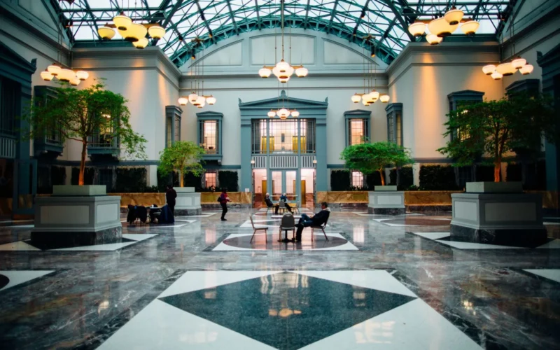 High-ceilinged lobby of a newly opened European luxury hotel with warm lighting and contemporary furnishings