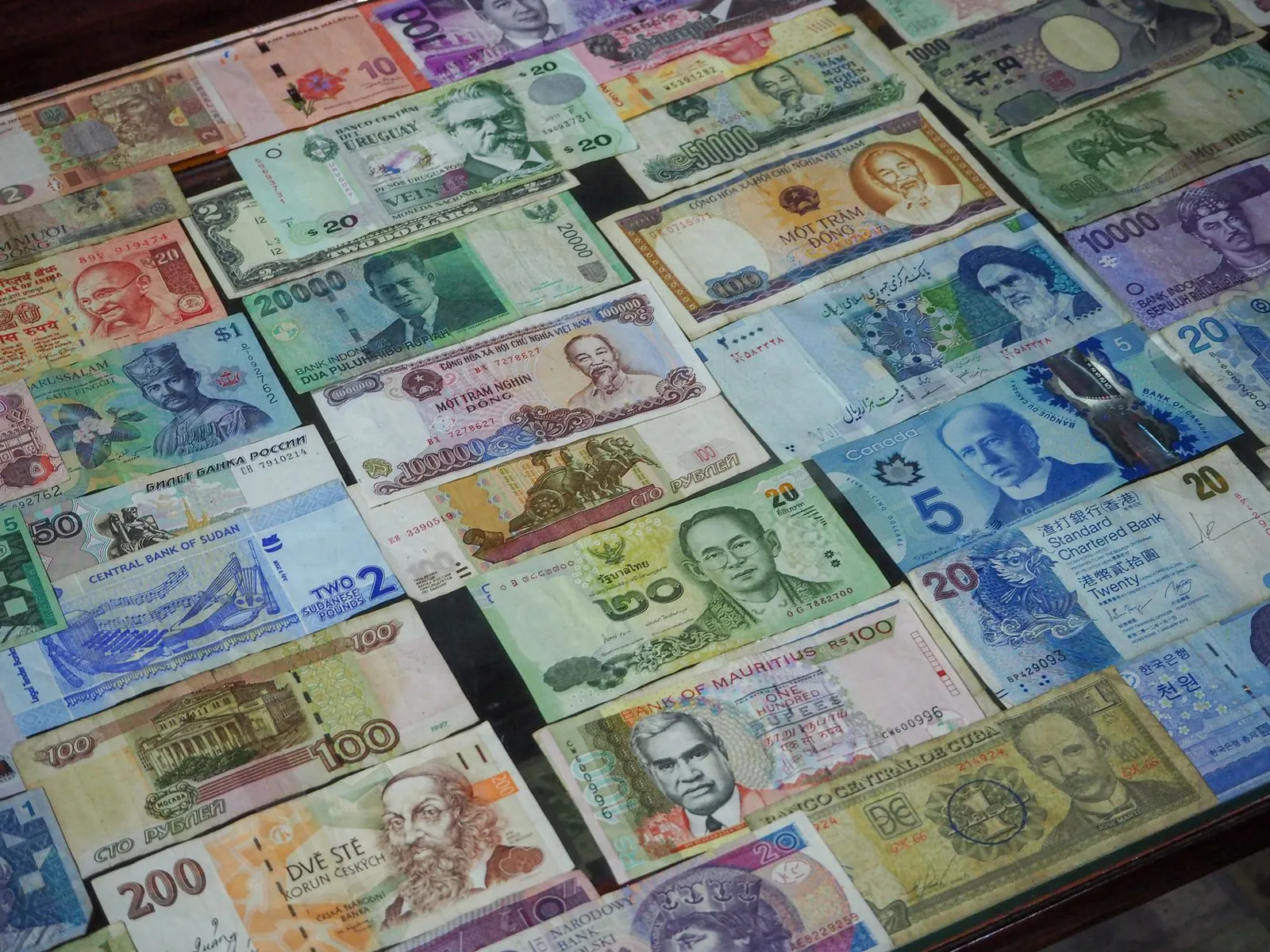Traveler withdrawing local currency from a major bank ATM on a city street abroad